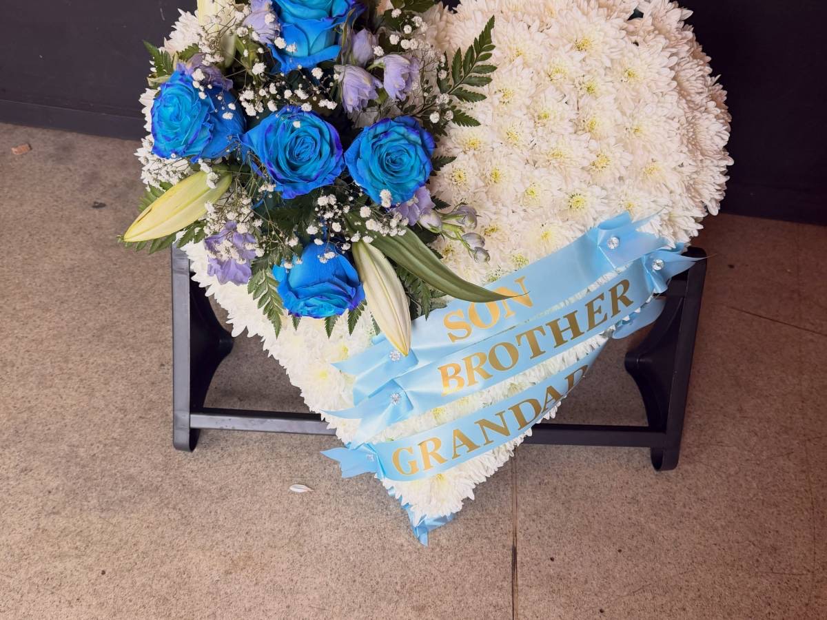 White heart tribute with blue roses and a ribbon